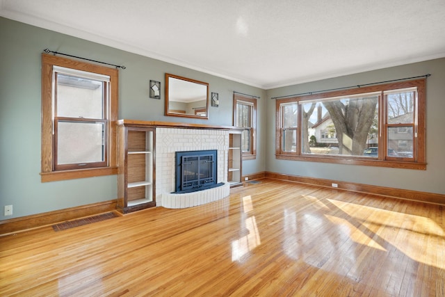 unfurnished living room with visible vents, baseboards, wood finished floors, and a fireplace