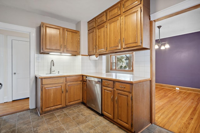 kitchen with dishwasher, light countertops, tasteful backsplash, and a sink