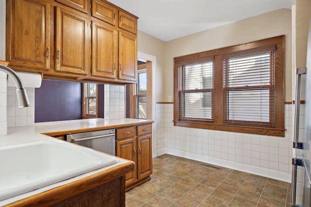 kitchen featuring brown cabinetry, visible vents, and light countertops