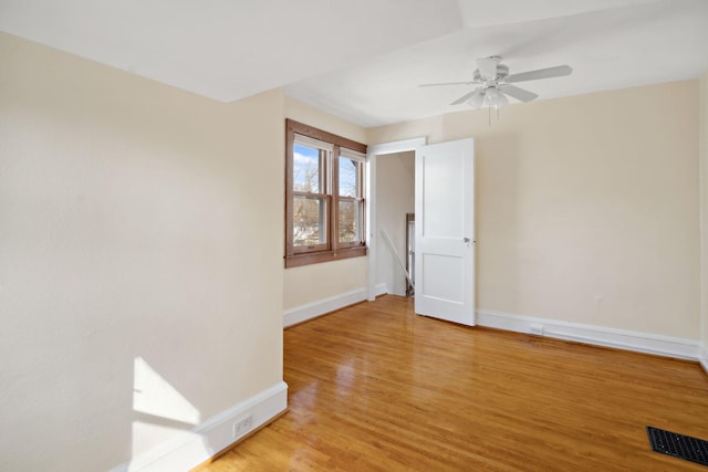 unfurnished room with visible vents, baseboards, light wood-style floors, and ceiling fan