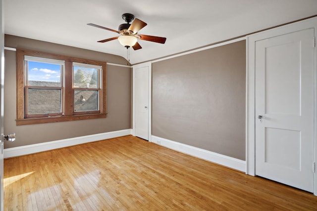 spare room with a ceiling fan, baseboards, and hardwood / wood-style floors