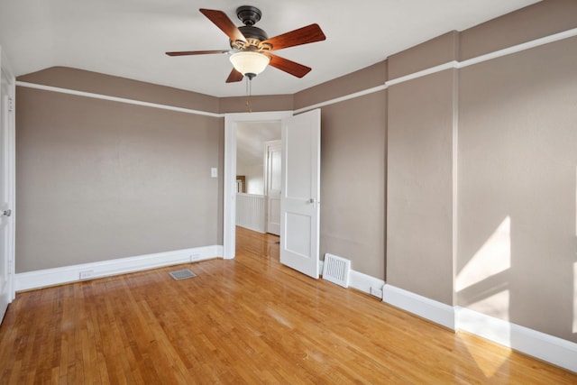 unfurnished room with visible vents, ceiling fan, baseboards, and wood finished floors