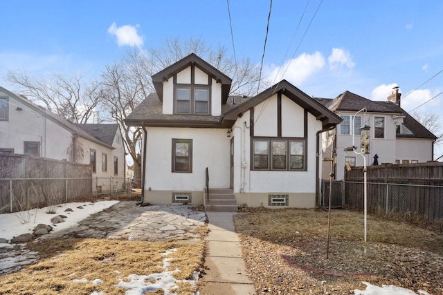 view of front facade with stucco siding, central AC, a fenced backyard, and roof with shingles