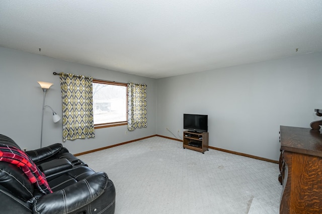 carpeted living area featuring baseboards