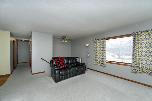 sitting room with carpet, an upstairs landing, baseboards, and a textured ceiling