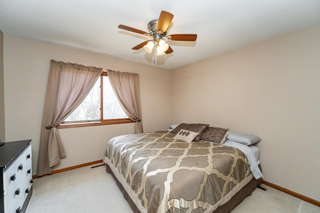 bedroom featuring light carpet, a textured ceiling, a ceiling fan, and baseboards