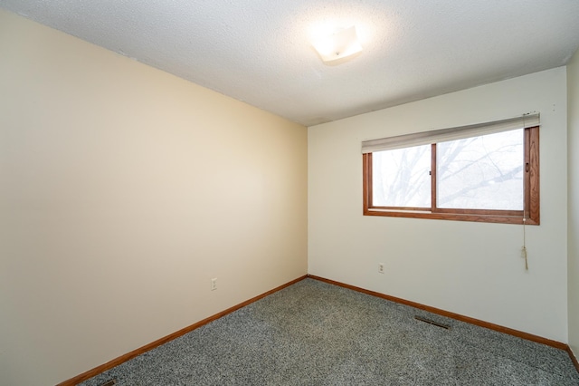 empty room with visible vents, baseboards, carpet, and a textured ceiling