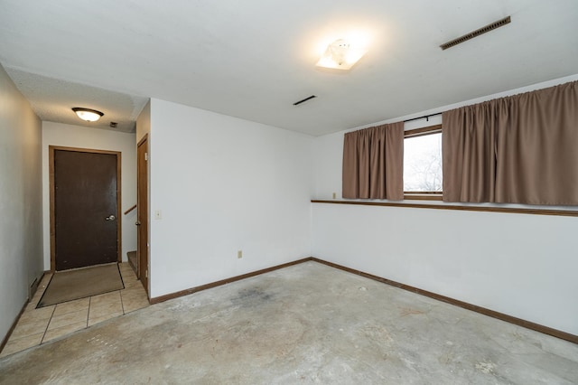 empty room featuring visible vents, baseboards, and concrete flooring