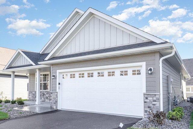 view of front of home featuring stone siding, board and batten siding, and roof with shingles