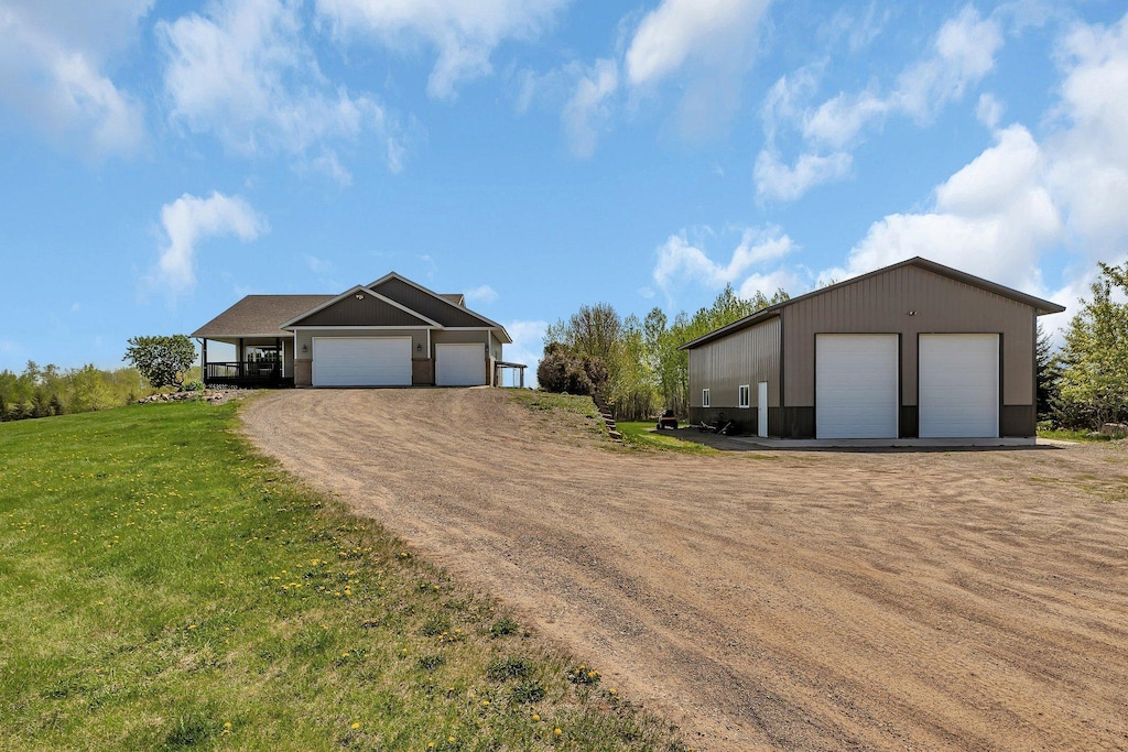 view of front of property with a front lawn, a garage, and an outbuilding