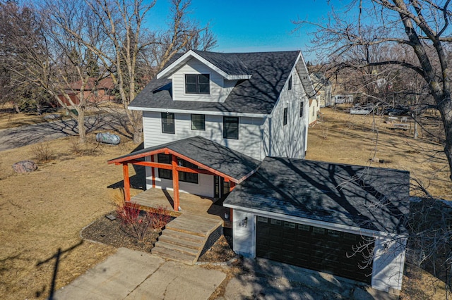 view of front of house with a garage and a shingled roof