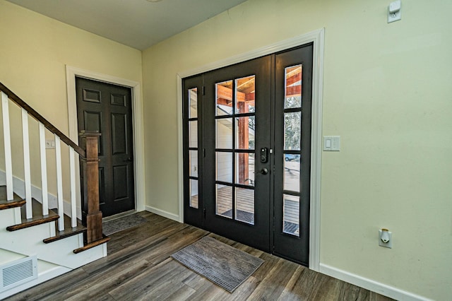 entrance foyer with visible vents, stairs, baseboards, and dark wood-style flooring