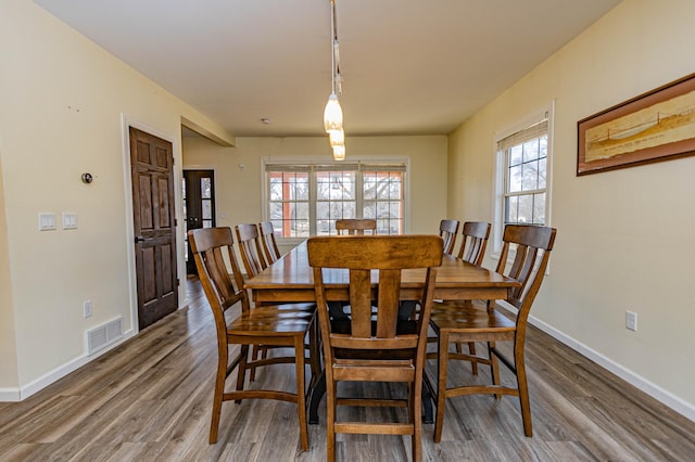 dining room with visible vents, baseboards, and wood finished floors