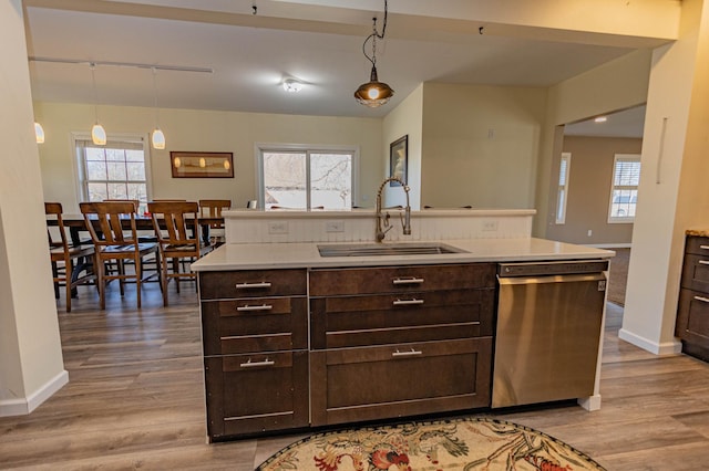 kitchen with a sink, dishwasher, a healthy amount of sunlight, and dark brown cabinets