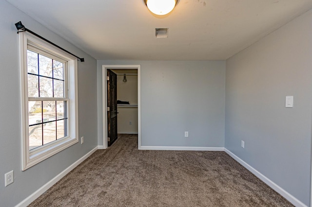 spare room featuring baseboards and carpet floors