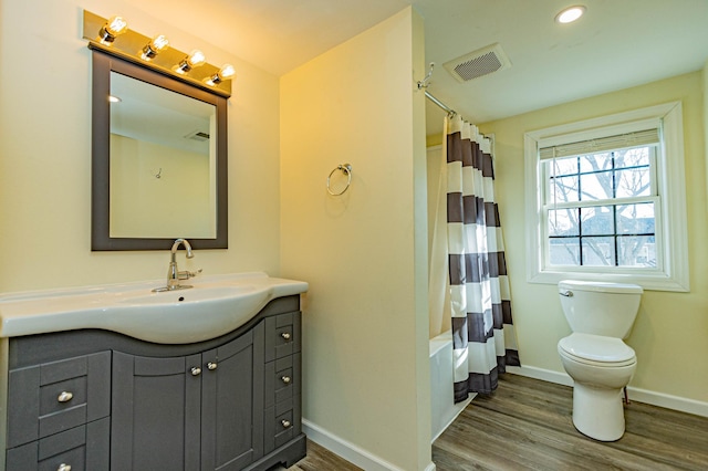 full bathroom featuring visible vents, baseboards, toilet, wood finished floors, and vanity