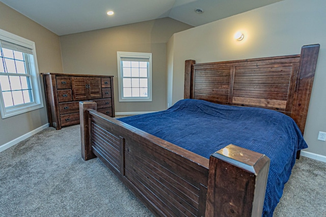 carpeted bedroom featuring multiple windows, lofted ceiling, baseboards, and visible vents