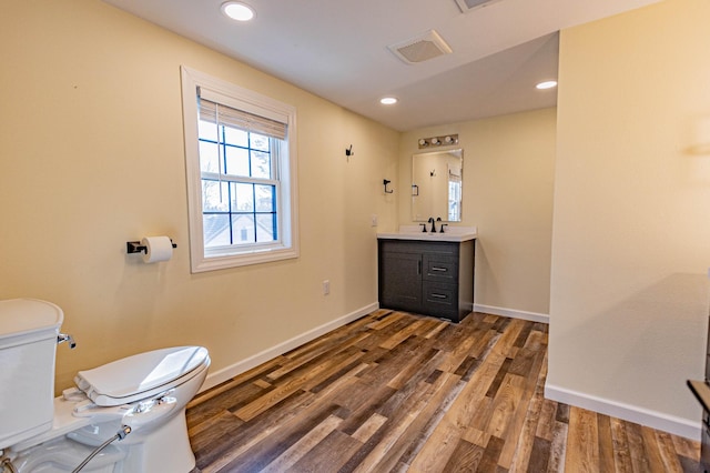 bathroom with vanity, wood finished floors, baseboards, recessed lighting, and toilet