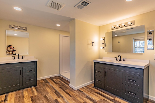 full bathroom featuring visible vents, two vanities, and a sink