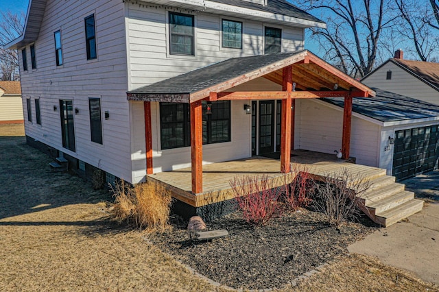 view of front of house featuring a garage and roof with shingles