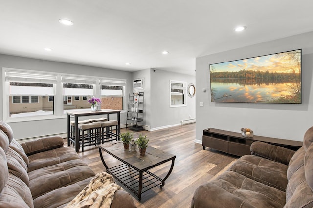 living area featuring a baseboard heating unit, baseboards, baseboard heating, recessed lighting, and wood finished floors