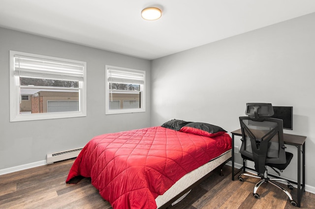 bedroom with baseboard heating, baseboards, and wood finished floors