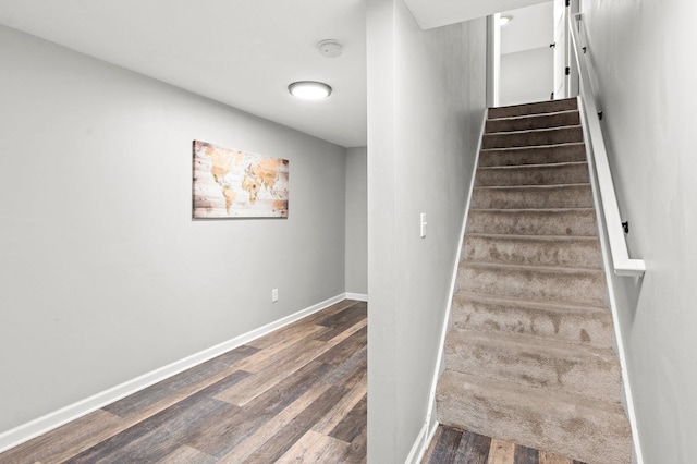 staircase with baseboards and wood finished floors