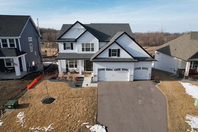 view of front of house featuring aphalt driveway, a garage, and roof with shingles