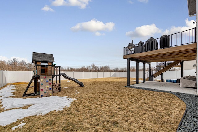 view of jungle gym featuring stairway, a patio, a lawn, and a fenced backyard