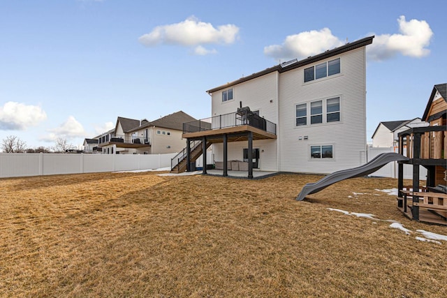 rear view of property featuring fence, a yard, stairs, a playground, and a patio area