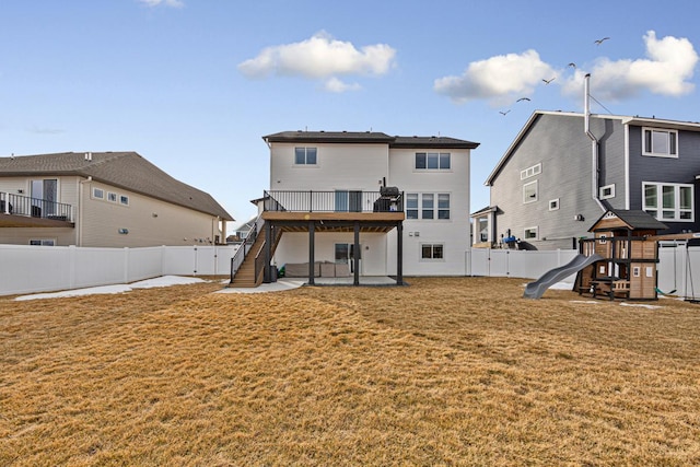 rear view of house with a playground, stairway, a yard, a fenced backyard, and a patio