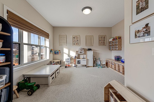 game room with carpet flooring, a textured ceiling, and baseboards