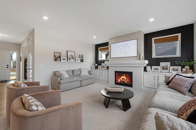 living room with recessed lighting and a lit fireplace