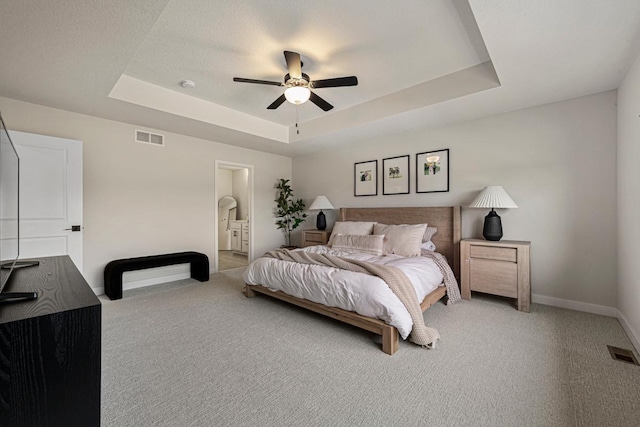 bedroom with a raised ceiling, baseboards, and visible vents