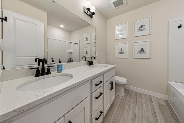 bathroom with a sink, visible vents, baseboards, and toilet