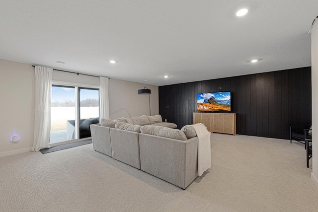 living area with recessed lighting, baseboards, light carpet, and wood walls