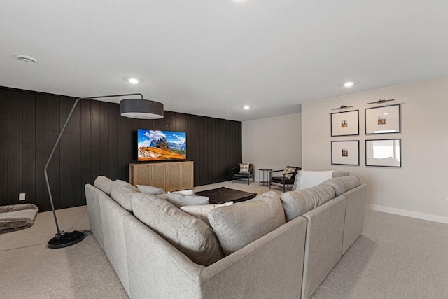 living room with recessed lighting, baseboards, carpet, and wood walls