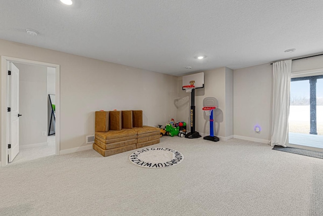 living area with carpet flooring, baseboards, visible vents, and a textured ceiling