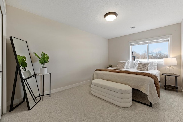 bedroom with a textured ceiling, baseboards, and carpet floors