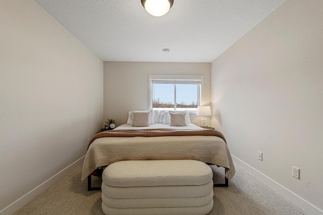 carpeted bedroom featuring a textured ceiling and baseboards