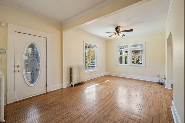 entryway featuring hardwood / wood-style flooring, radiator heating unit, baseboards, and ornamental molding