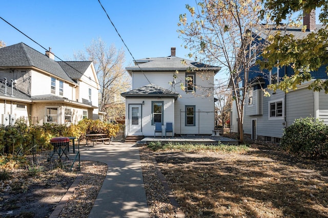 rear view of property featuring a patio and a chimney