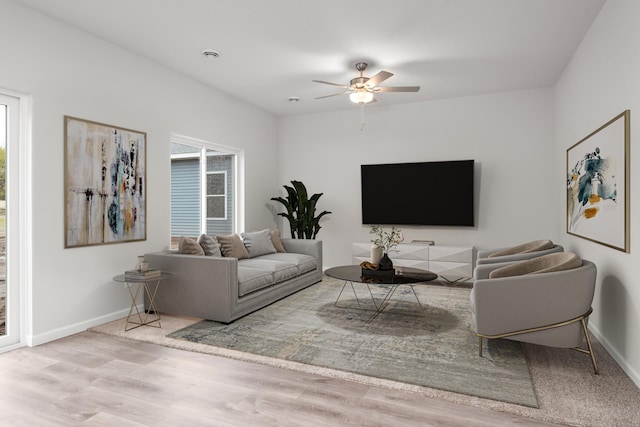 living area with wood finished floors, baseboards, and ceiling fan