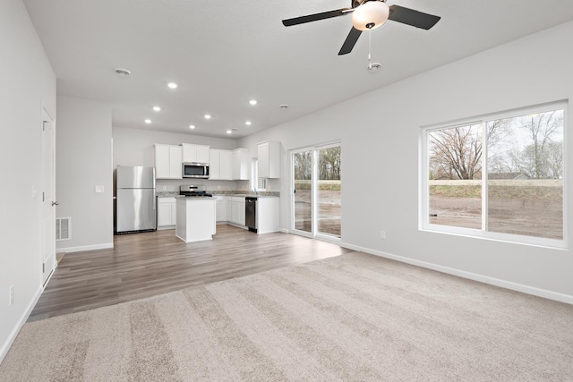 unfurnished living room featuring baseboards, visible vents, recessed lighting, ceiling fan, and light wood-style floors