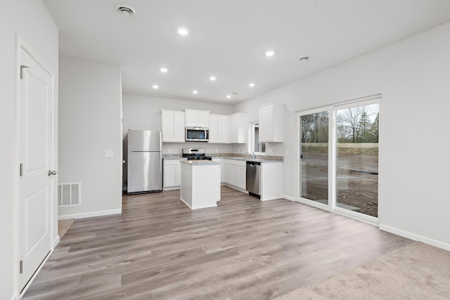 kitchen featuring visible vents, a kitchen island, recessed lighting, appliances with stainless steel finishes, and white cabinetry