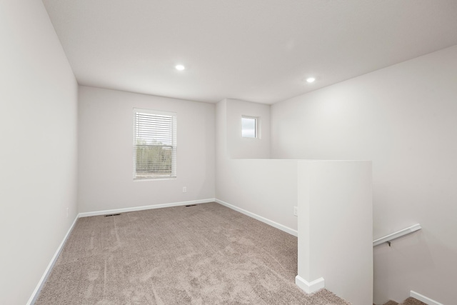 carpeted spare room featuring visible vents, recessed lighting, and baseboards