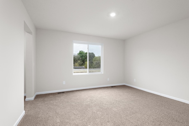 unfurnished room featuring baseboards, carpet floors, and visible vents