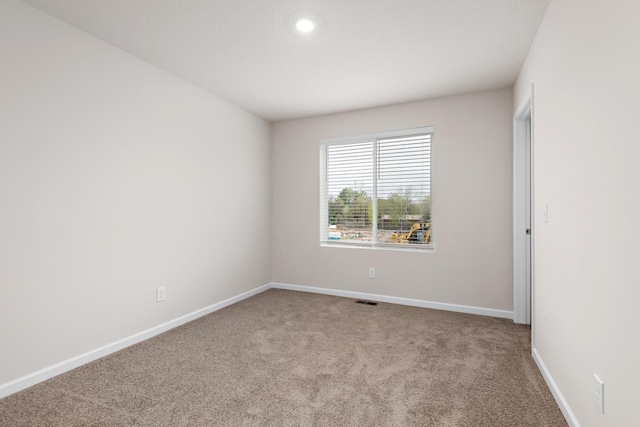 carpeted empty room featuring recessed lighting, visible vents, and baseboards