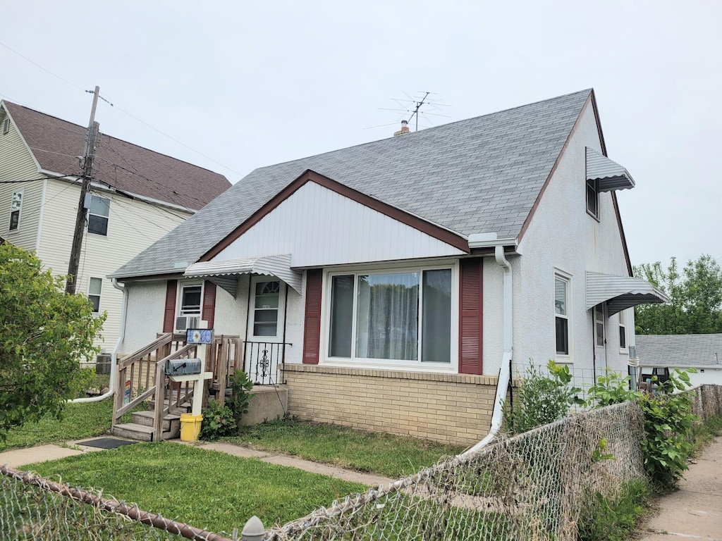 view of front of house featuring brick siding and roof with shingles