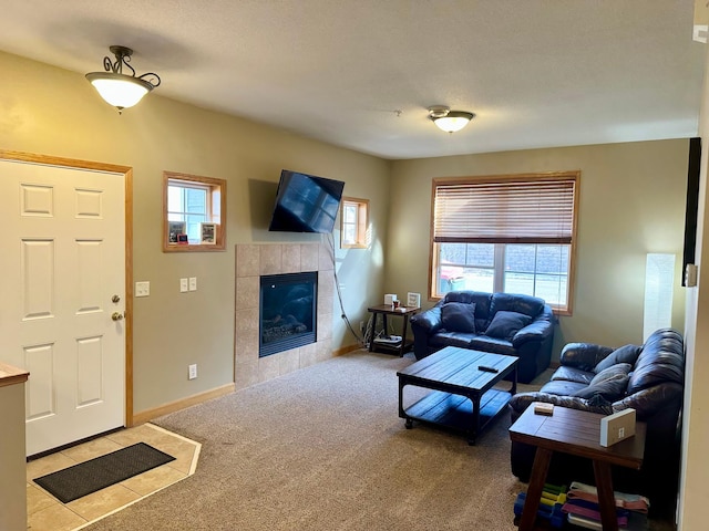 carpeted living area with a fireplace, a healthy amount of sunlight, and baseboards